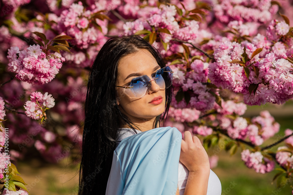 Girl in cherry blossom flower. Woman fancy sunglasses in spring flower bloom. Spring fashion collection. Sakura tree blooming. Passionate about spring. Clothes shop. Gorgeous fancy girl outdoors