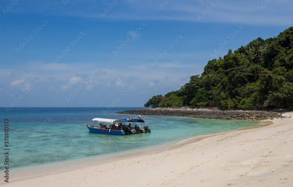 Tourist boats moored on a beach on the tropical island of Pulau Tulai, Malaysia