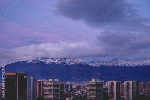 Beautiful panorama of purple and blue cloudy sunset sky over Santiago skyline and Los Andes mountains, Chile