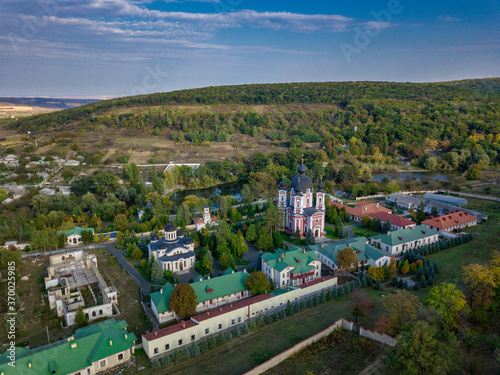 Flight over a christian monastery surrounded by autumn forest. Kurky monastery, Moldova republic of.