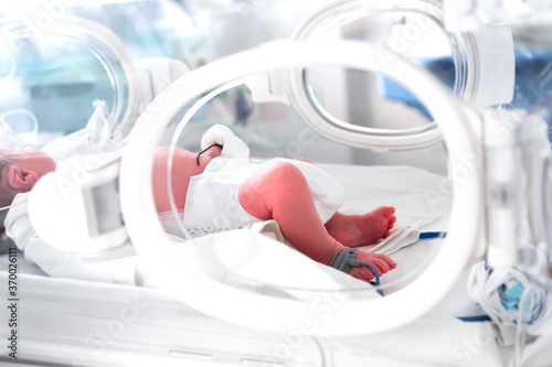 Close up of a foot of a premature newborn with a premature infant pulse oximeter on his foot, placed in a premature newborn incubator. Neonatal intensive care unit