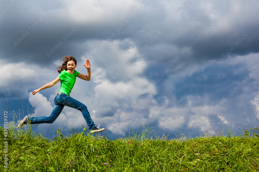 Girl jumping, running against cloudy sky
Girl jumping, running against cloudy sky