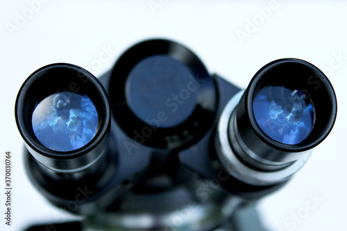 Black microscope on a white background, horizontal view. Medicine, science, research concept.