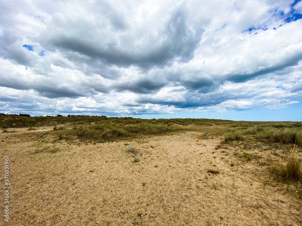 Great Yarmouth beach in a summer day, traditional UK English East Coast landscape, blue and brown, sky with clouds no people, large stretch of sand, UK beaches Great Yarmouth beach in a summer day, traditional UK English East Coast landscape, blue and brown, sky with clouds no people, large stretch of sand, UK beaches