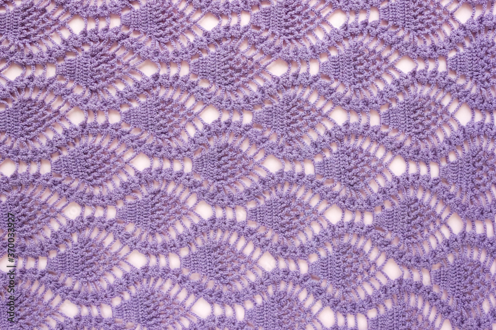 Knitted pattern of lilac threads. Background for handicrafts and hobbies. Top view.