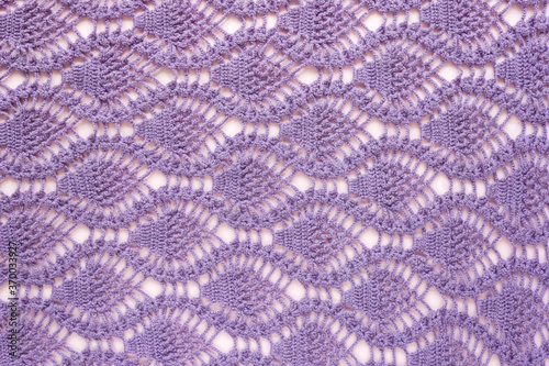 Knitted pattern of lilac threads. Background for handicrafts and hobbies. Top view.