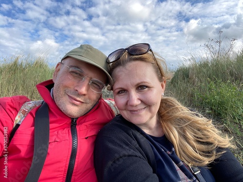 Holiday selfy of couple outdoor, UK summer with cloudy sky