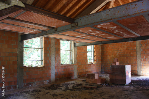 ceiling of a house under construction with red brick and exposed beams