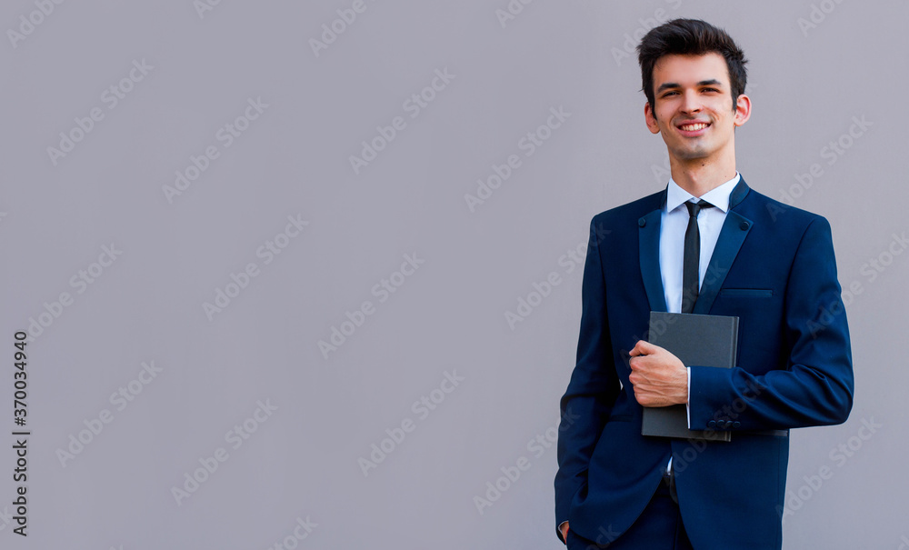 Shot of an elderly managing director with diary standing on gray background Shot of an elderly managing director with diary standing on gray background