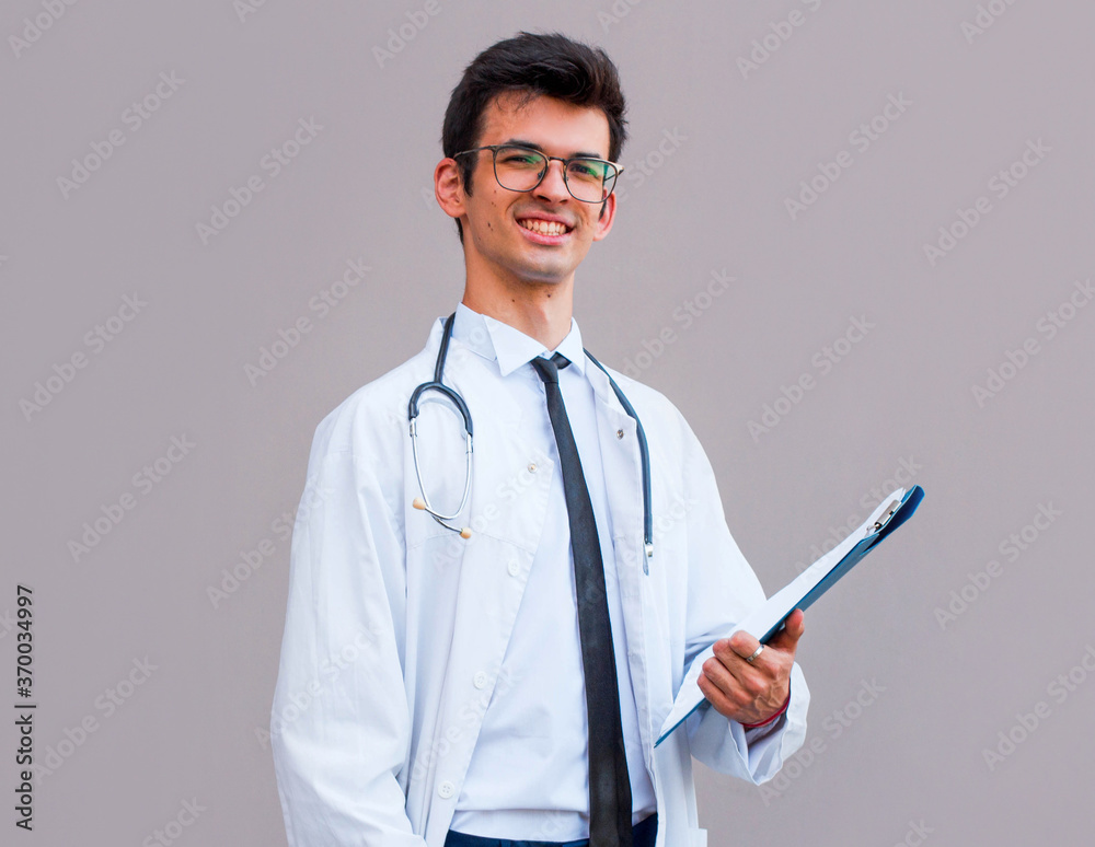 Portrait of confident young medical doctor on gray background Portrait of confident young medical doctor on gray background