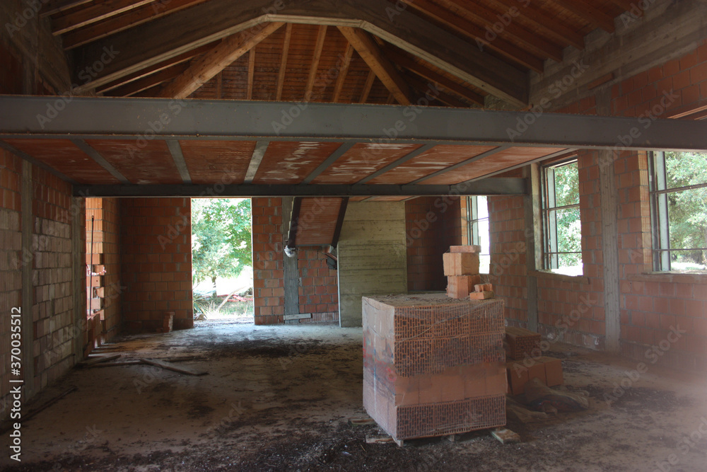ceiling of a house under construction with red brick and exposed beams