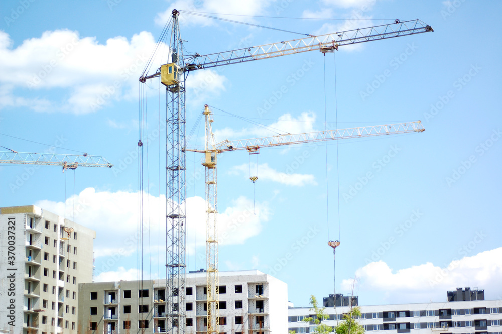 Construction of a new house in the city area. Construction crane. Construction of a new house in the city area. Construction crane.