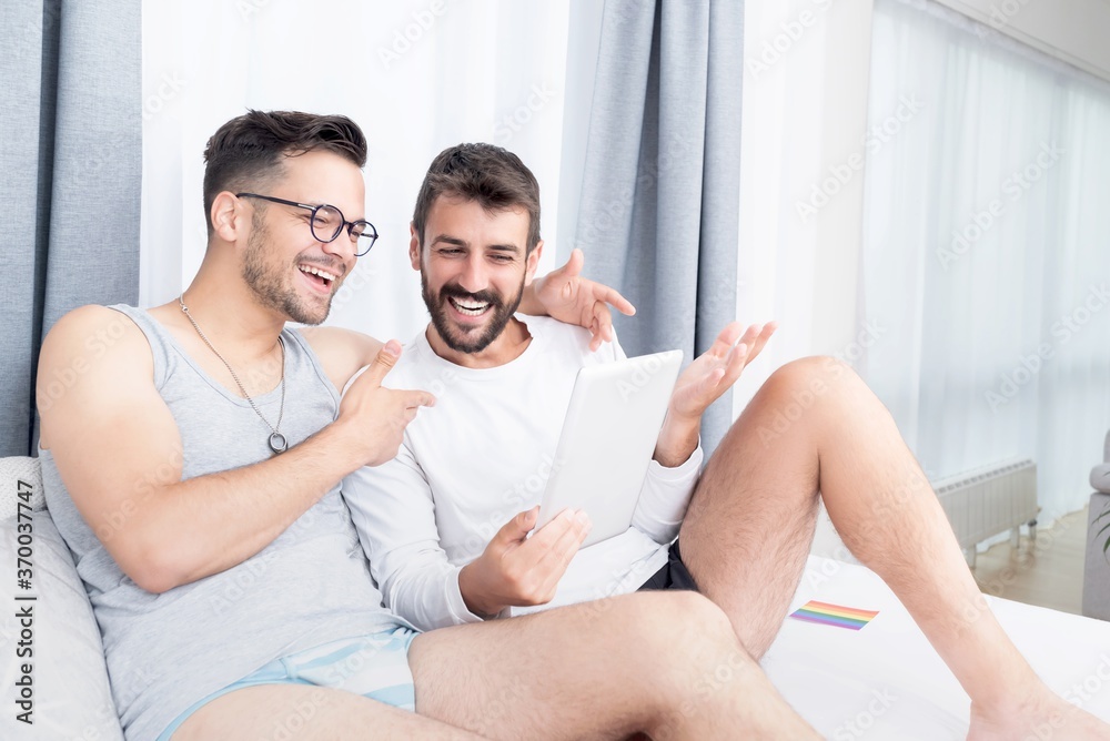 Gay couple enjoying video chat using digital tablet at home Photos | Adobe  Stock