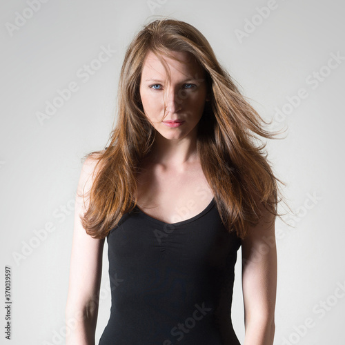 Closeup portrait of a beautiful young woman wearing a black shirt in front of bright background