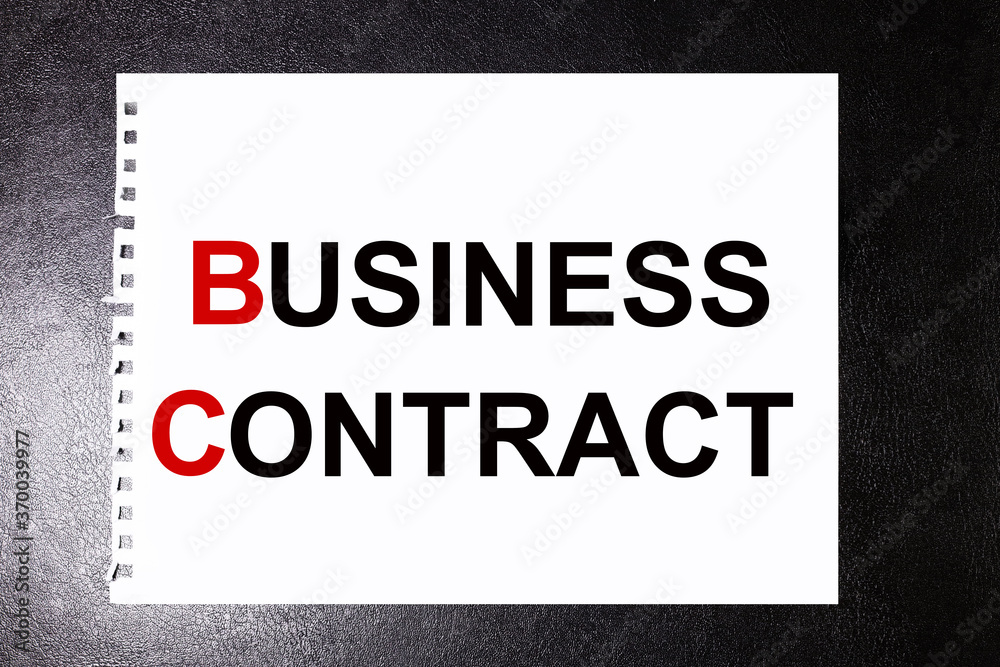 business contract. text on white sheet of paper on black background business contract. text on white sheet of paper on black background
