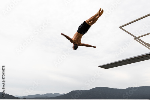 Man Doing Backflip Off Diving Board