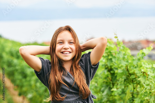 Outdoor portrait of adorable kid girl playing in green park