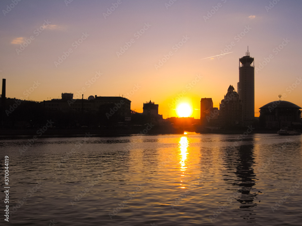 Sunset on the Moscow river, urban cityscape, silhouettes of buildings