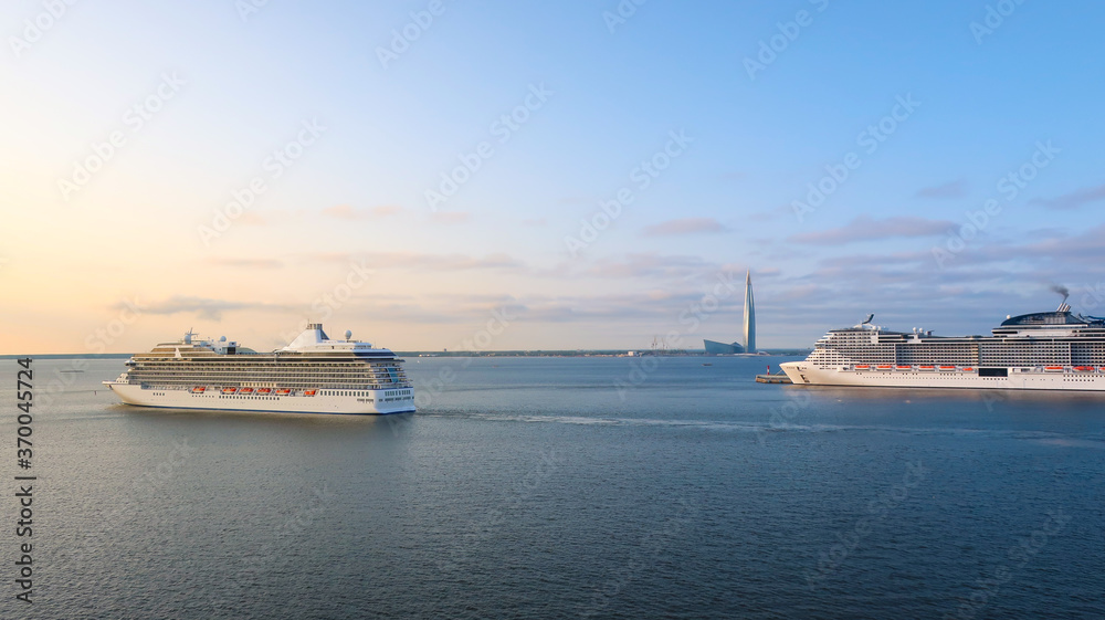 Ships and luxury liners sail and dock at the cruise port of Saint Petersburg, Russia with Europe's tallest skyscraper, the Lakhta center in view on the coast of Gulf of Finland