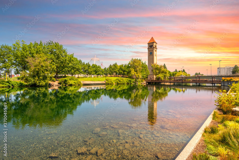 The Spokane Clock Tower and Pavilion along the river in Riverfront Park, downtown Washington, under a colorful sunset in Spokane, Washington, USA