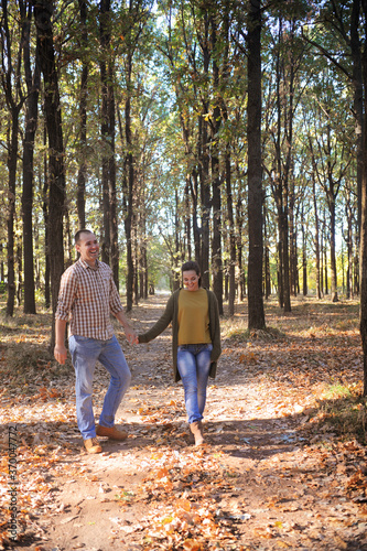 Happy love couple walking in forest and embracing  young family portrait  casual wear