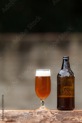 Glass of beer and bottle on wood table