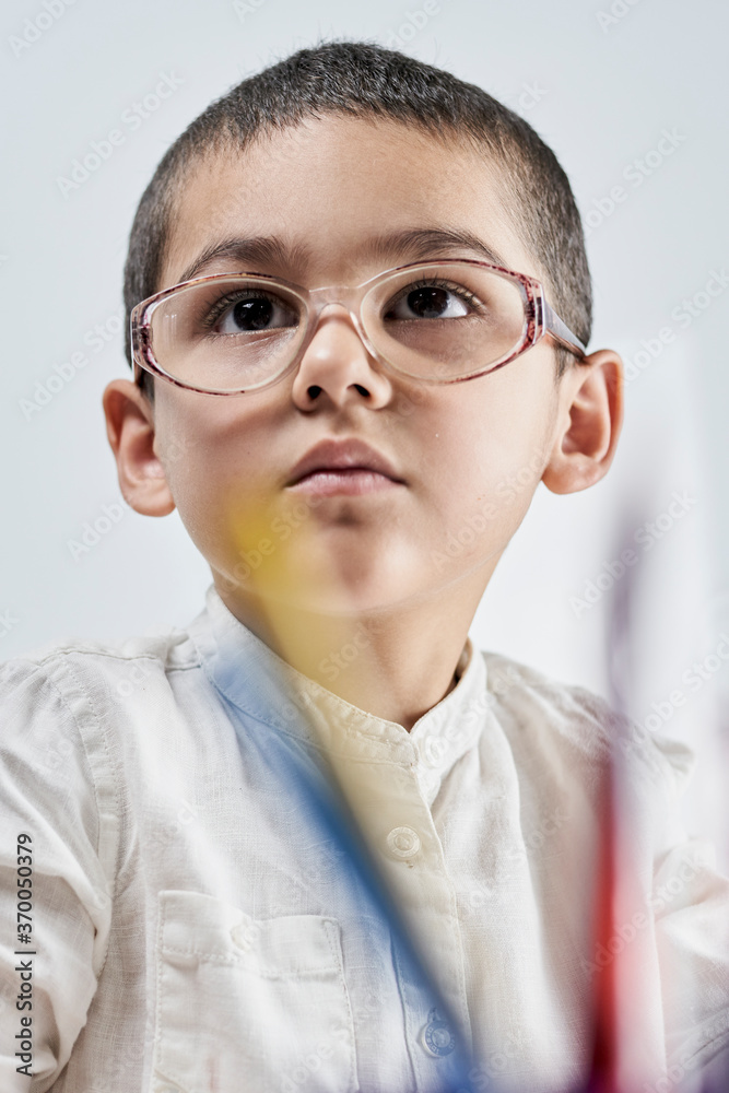 Vertical portrait of a cute smart boy in glasses Vertical portrait of a cute smart boy in glasses