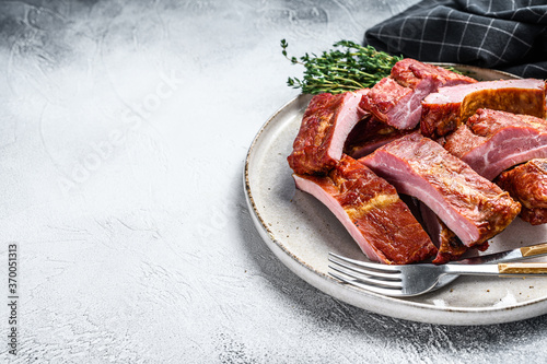 Sliced bbq pork ribs in a sauce. Gray background. Top view. Copy space