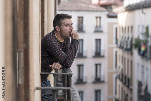 Wallpaper Mural urban lifestyle emotional portrait of young handsome man sad and depressed smoking cigarette thoughtful at home balcony leaning unhappy feeling bittered   suffering some problem Torontodigital.ca