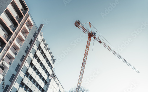 Fotografi Tilted diagonal view from the ground of a high construction crane in a residenti
