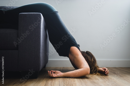 Young woman collapsed and tired laying off end of sofa
