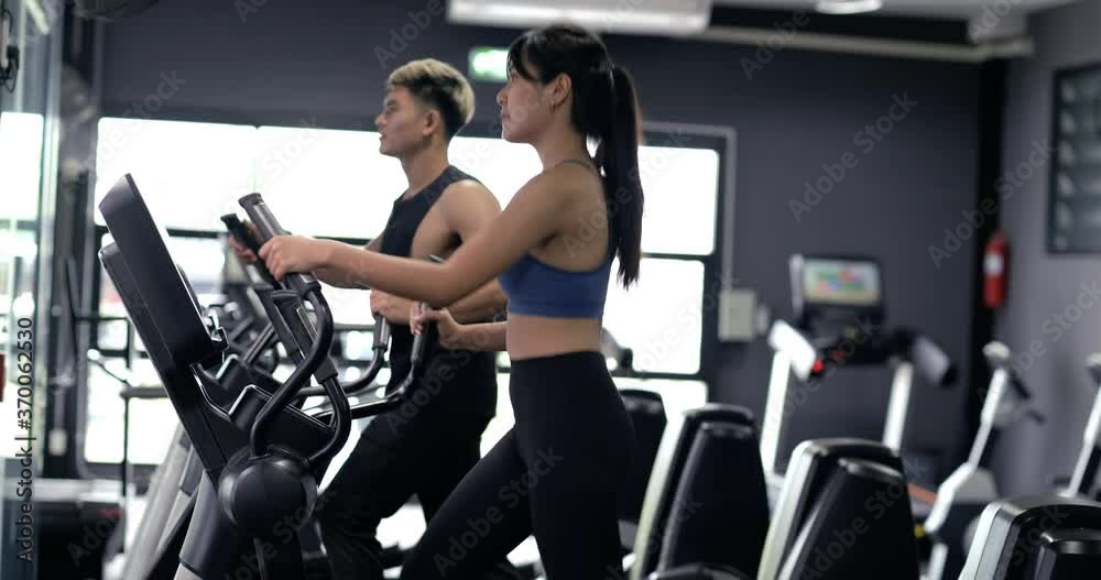 Two asian with elliptical cardio exercising active healthy lifestyle. Two asian with elliptical cardio exercising active healthy lifestyle.