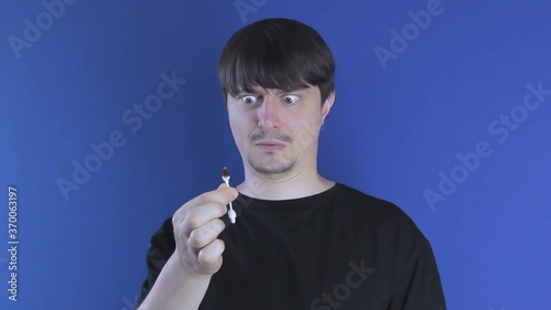 A man cleans his ears with a cotton swab and pulls out earwax