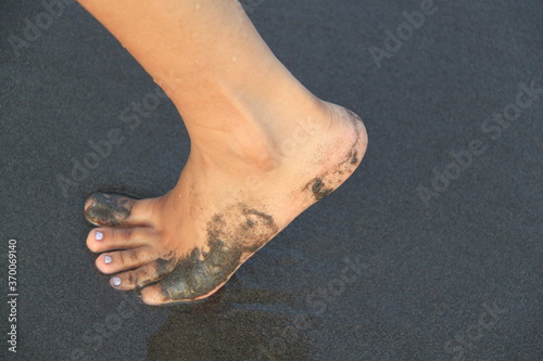 foot on the black sand beach photo