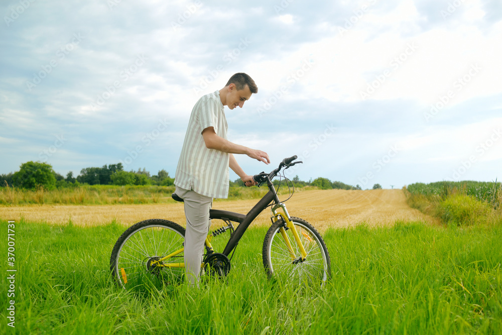 Obraz premium A man on a mountain bike. A fashionable guy came to nature in the field.