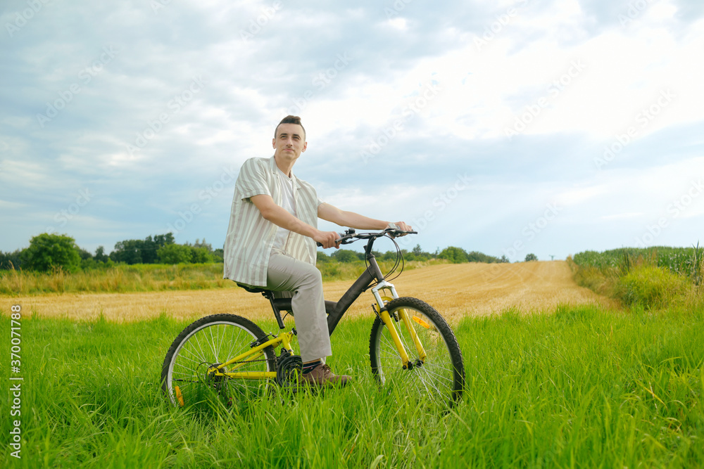 Obraz premium A man on a mountain bike. A fashionable guy came to nature in the field.