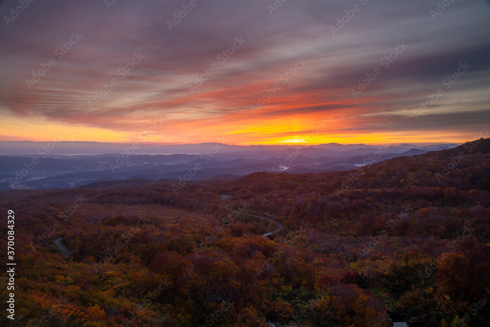 朝焼けに染まる鳥海山山麓の紅葉