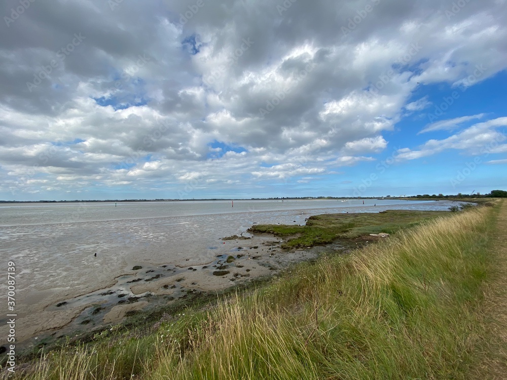 View of the broads National Park from the river bank in a cloudy day shoot taken against the sun with a dramatic sky and strong shadow in Great Yarmouth View of the broads National Park from the river bank in a cloudy day shoot taken against the sun with a dramatic sky and strong shadow in Great Yarmouth