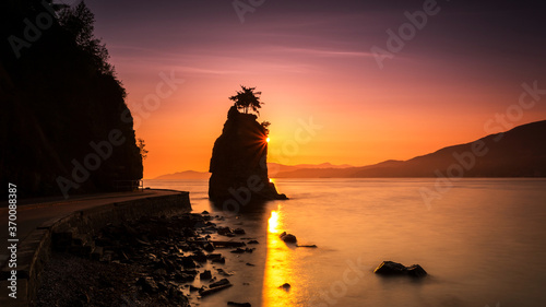 Silhouette of Siwash Rock at Sunset in the beautiful Stanley park, Vancouver, British Columbia, Canada photo