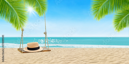 Summer Vacation and Holiday Trip Concept : Weave hat put on wooden swing with beautiful tropical seascape view and sunlight in background.