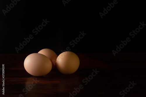 huevos frescos color café sobre un fondo color negro para mostrar producto o información.