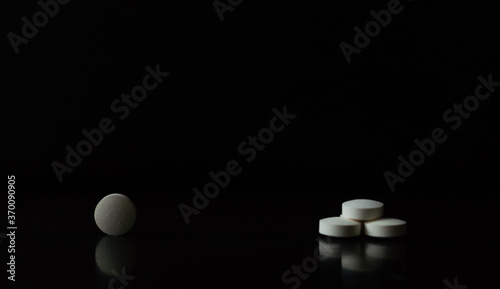 Tabletas o pastillas blancas sobre un fondo negro para mostrar información o algún producto
