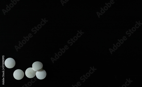 Tabletas o pastillas blancas sobre un fondo negro para mostrar información o algún producto