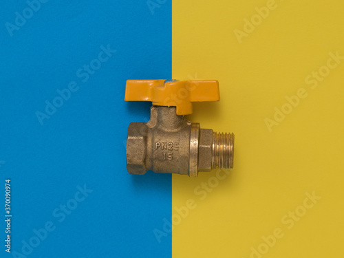 Yellow gas tap on a yellow and blue background. photo