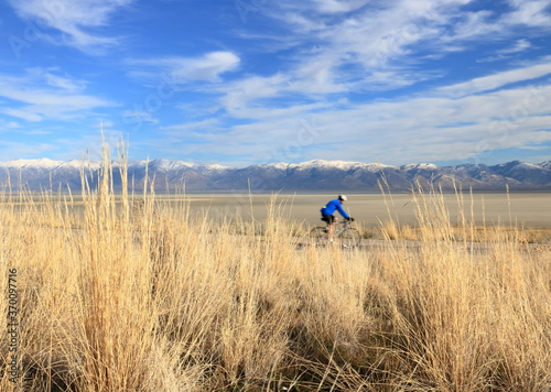 Biker rides enjoying mountain and lake vistas at Antelope Island, Utah