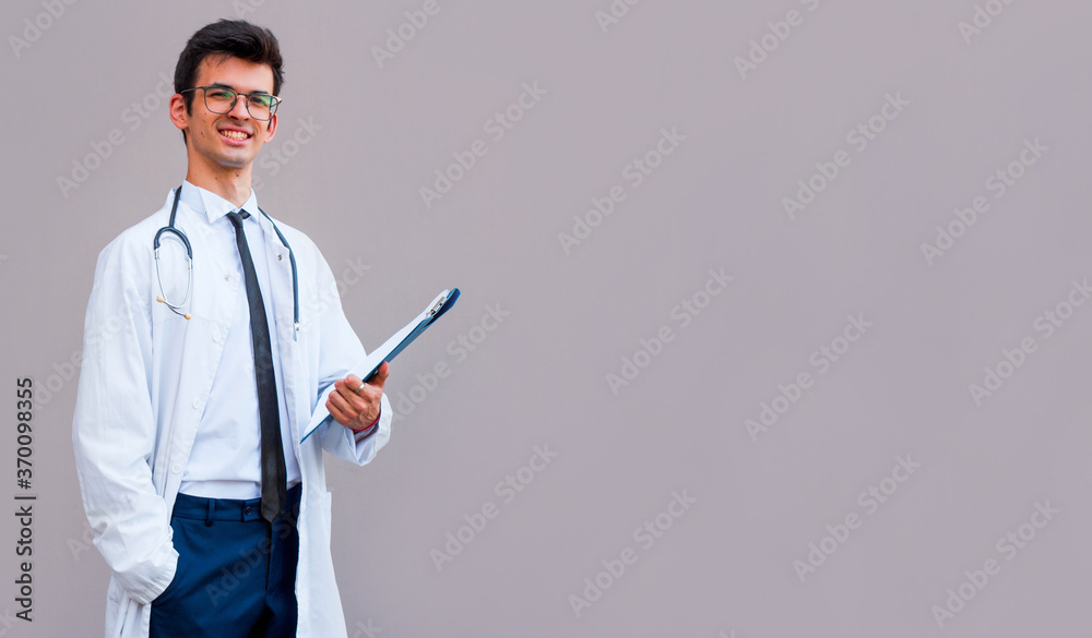 Portrait of confident young medical doctor on gray background Portrait of confident young medical doctor on gray background