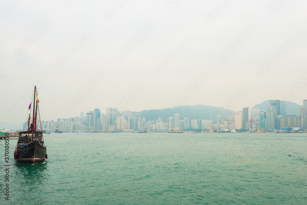 Fototapeta premium Hong Kong victoria harbour with tourist junk red flag boat