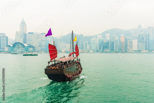 Hong Kong victoria harbour with tourist junk red flag boat