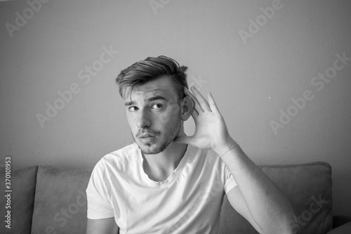 Black and White, Young white man with white shirt over green wall listening something