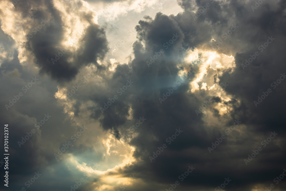 dramatic sky with sunbeams shining through the clouds after a storm at sunset dramatic sky with sunbeams shining through the clouds after a storm at sunset